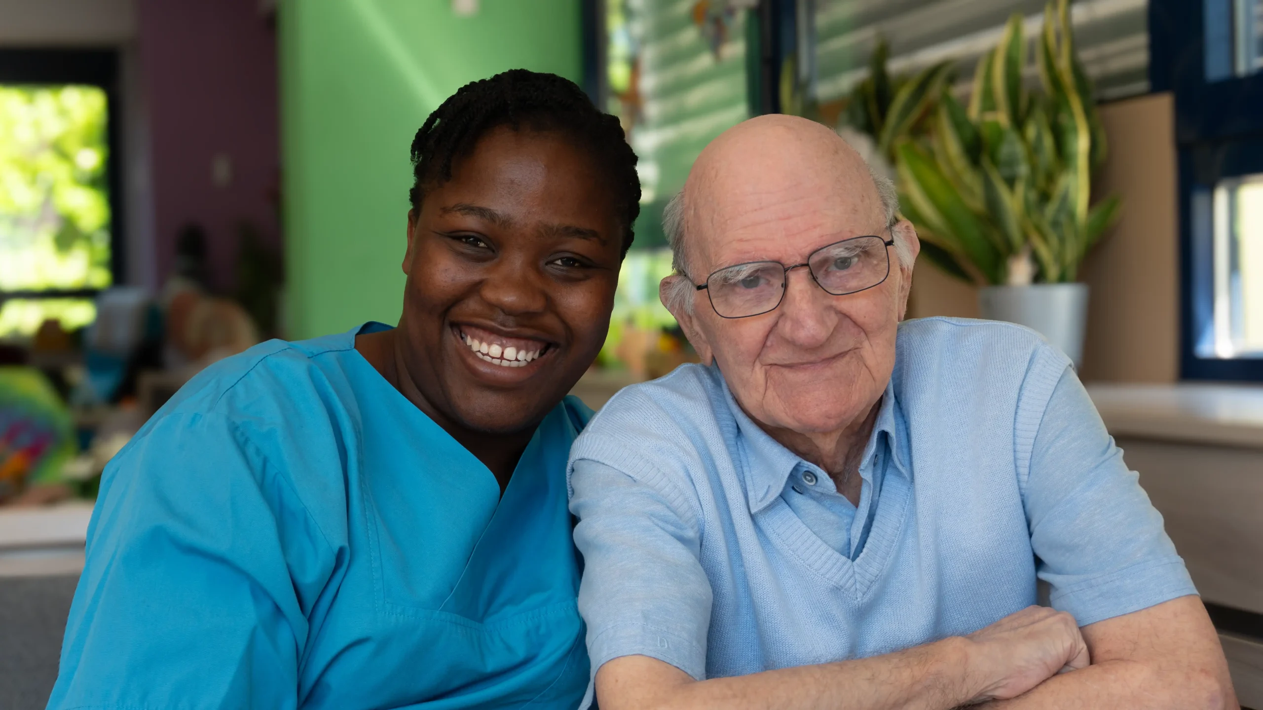Pflegekraft und Senior lachen gemeinsam