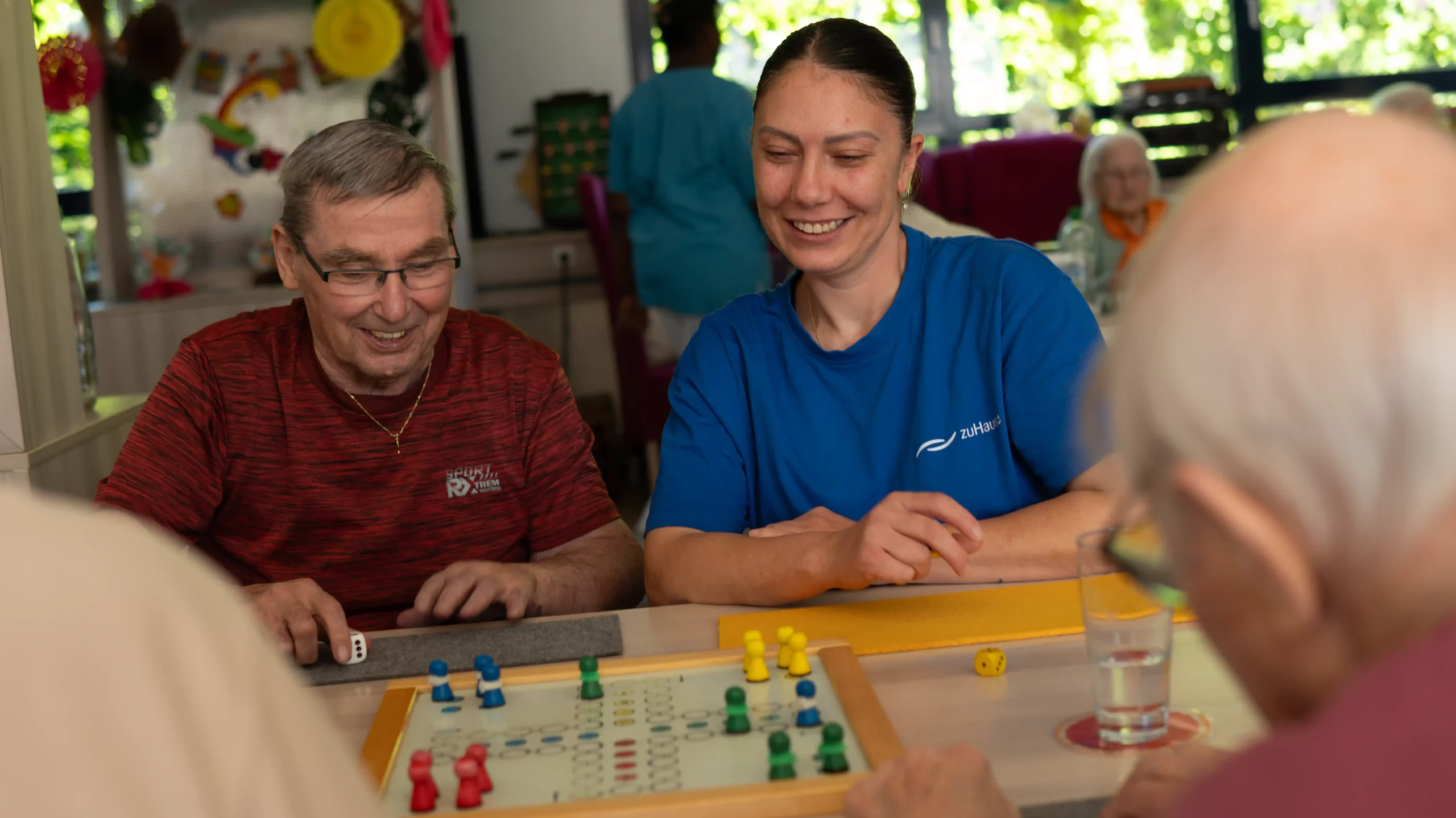 Pflegekraft und Senior beim Brettspiel