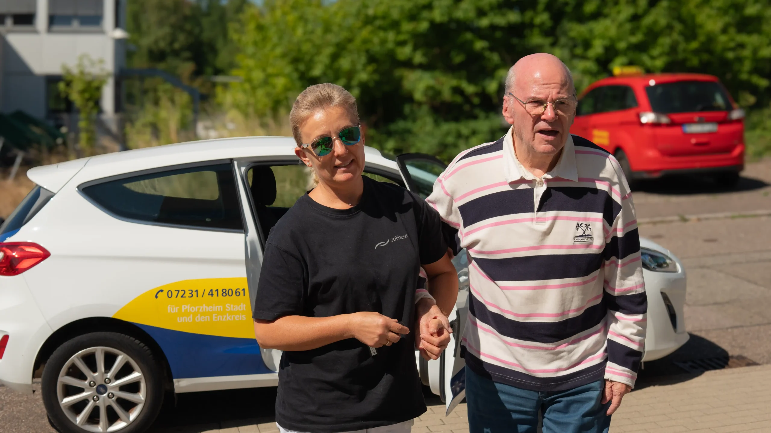 Pflegekraft begleitet Senior zum Auto